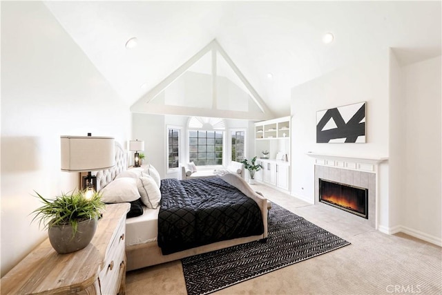 bedroom featuring a fireplace, light colored carpet, and high vaulted ceiling