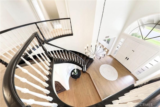 stairs with wood-type flooring and a high ceiling