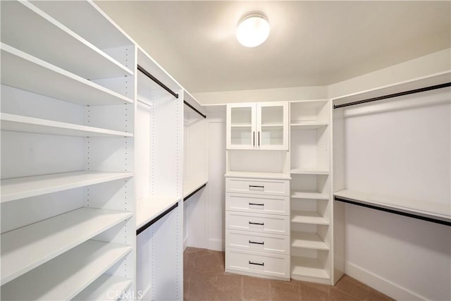 walk in closet with light colored carpet