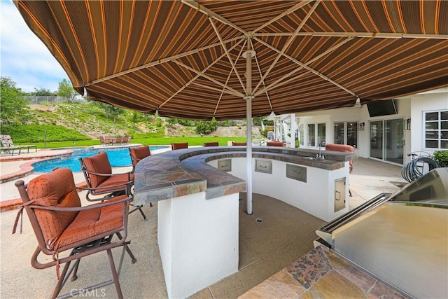 view of patio / terrace with exterior kitchen and an outdoor bar