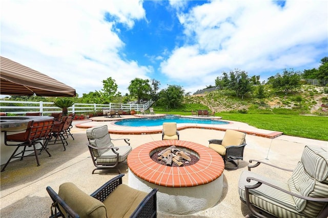 view of swimming pool with a fire pit and a patio area