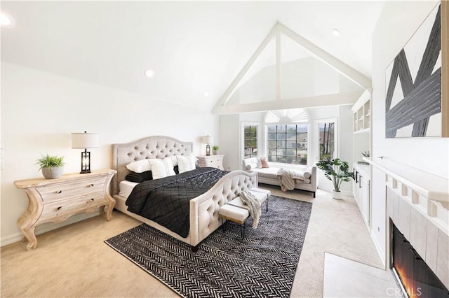 bedroom with carpet flooring, a fireplace, and high vaulted ceiling