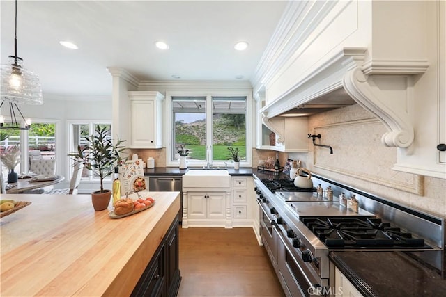 kitchen featuring tasteful backsplash, a wealth of natural light, white cabinets, and hanging light fixtures