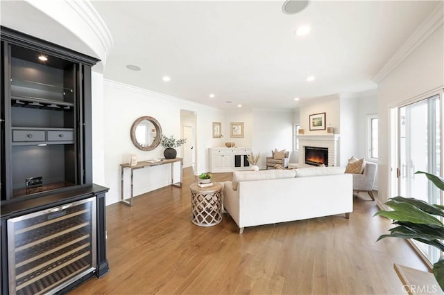 living room featuring hardwood / wood-style flooring, crown molding, and wine cooler