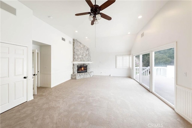 unfurnished living room with light carpet, high vaulted ceiling, ceiling fan, and a fireplace