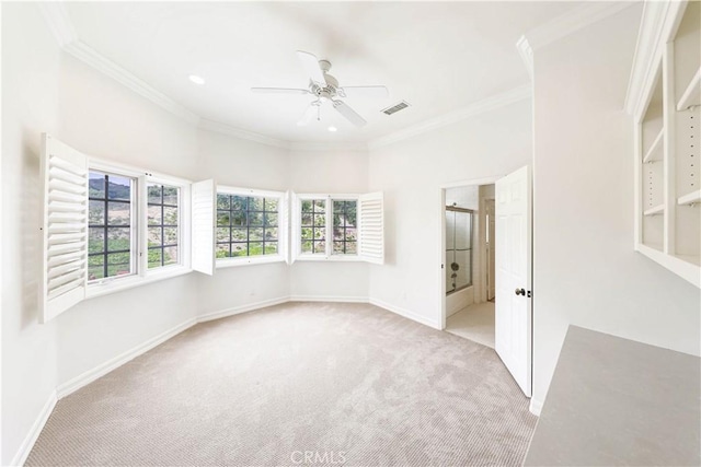 empty room with ceiling fan, crown molding, and light carpet