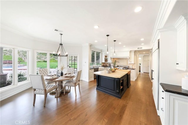 kitchen with dark hardwood / wood-style flooring, decorative light fixtures, a kitchen island, and plenty of natural light