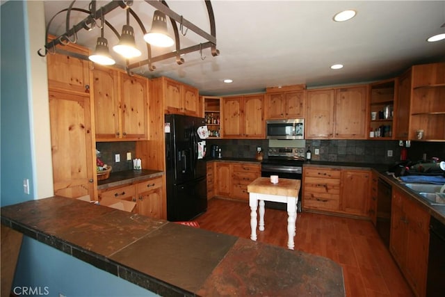 kitchen featuring black appliances, dark hardwood / wood-style floors, kitchen peninsula, and tasteful backsplash