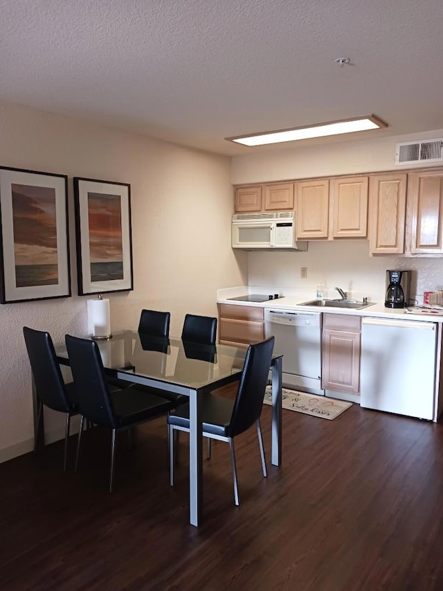 dining room with a textured ceiling, dark wood-type flooring, and sink