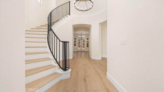 staircase featuring hardwood / wood-style floors and a chandelier