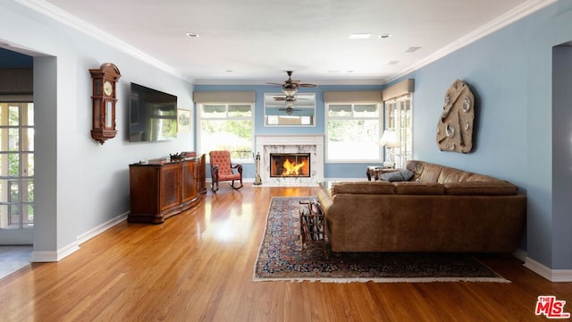 living room featuring a premium fireplace, ceiling fan, plenty of natural light, and hardwood / wood-style flooring