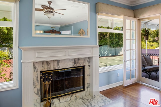 interior details featuring ceiling fan, hardwood / wood-style floors, a fireplace, and ornamental molding