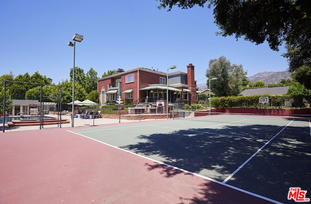 view of sport court with a fenced in pool