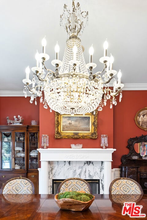 details featuring a notable chandelier, a high end fireplace, and crown molding