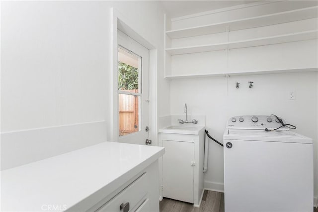 washroom with cabinets, light wood-type flooring, sink, and washer / clothes dryer