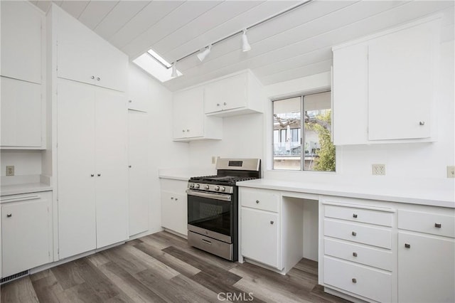 kitchen featuring white cabinets, stainless steel range with gas cooktop, rail lighting, light hardwood / wood-style flooring, and vaulted ceiling with skylight