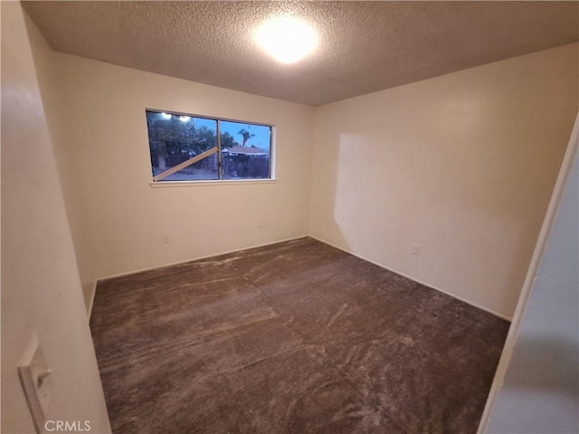 carpeted spare room with a textured ceiling