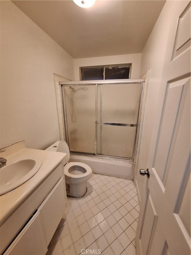 full bathroom featuring tile patterned floors, shower / bath combination with glass door, vanity, and toilet