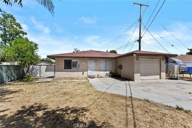 315 S Mistletoe Ave, San Jacinto, CA 92583 - view of front facade featuring stucco siding, a garage, concrete driveway, and a gate