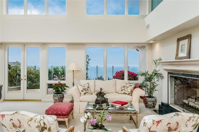 sunroom with a healthy amount of sunlight, a water view, and a premium fireplace