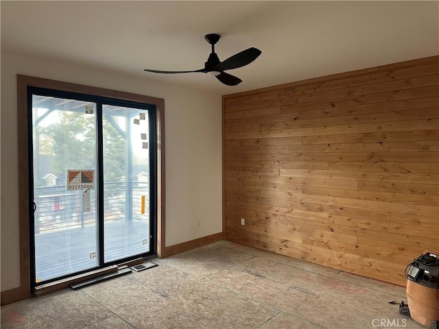 spare room with wooden walls and ceiling fan