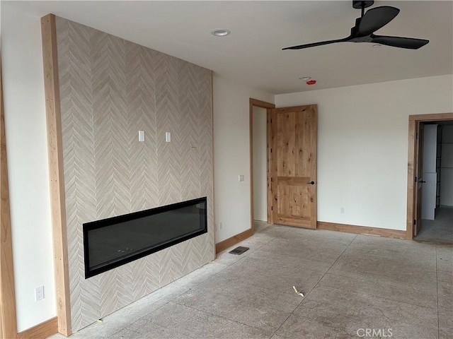 unfurnished living room featuring a fireplace and ceiling fan