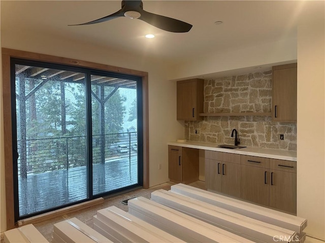 interior space with ceiling fan, sink, and backsplash