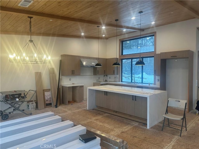 kitchen featuring a high ceiling, hanging light fixtures, sink, and wooden ceiling