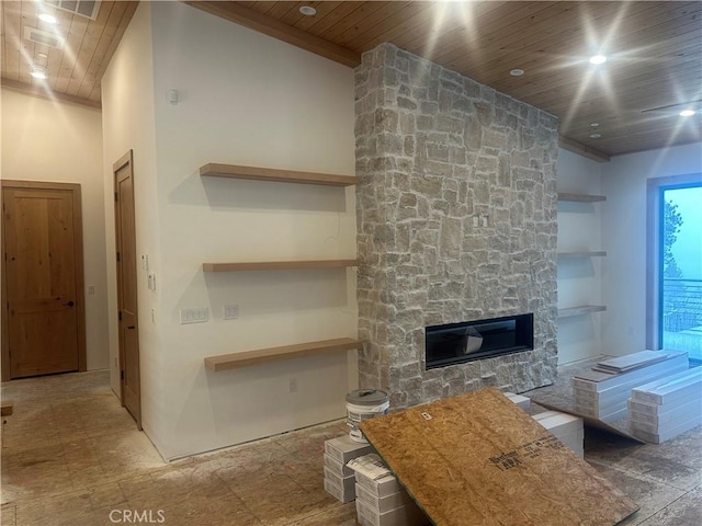 living room with wood ceiling and a stone fireplace