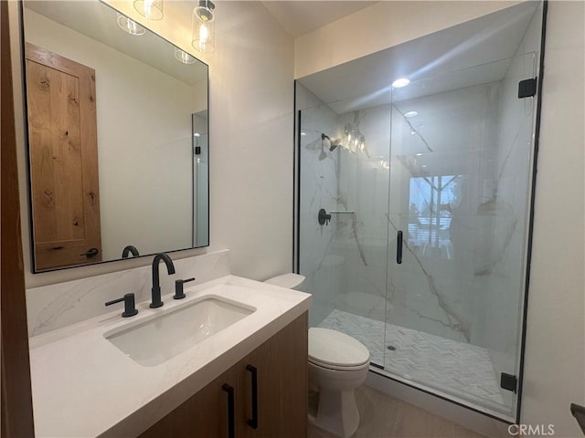 bathroom featuring a shower with door, vanity, and toilet