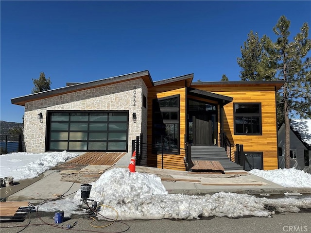 contemporary home with a garage and stone siding