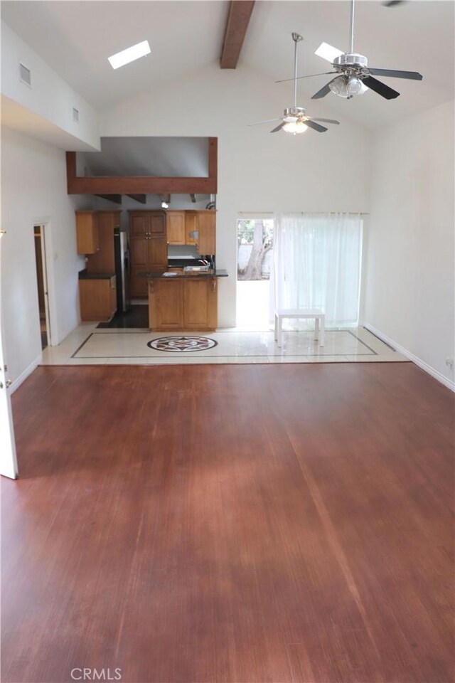 unfurnished living room with beam ceiling, high vaulted ceiling, ceiling fan, and hardwood / wood-style floors