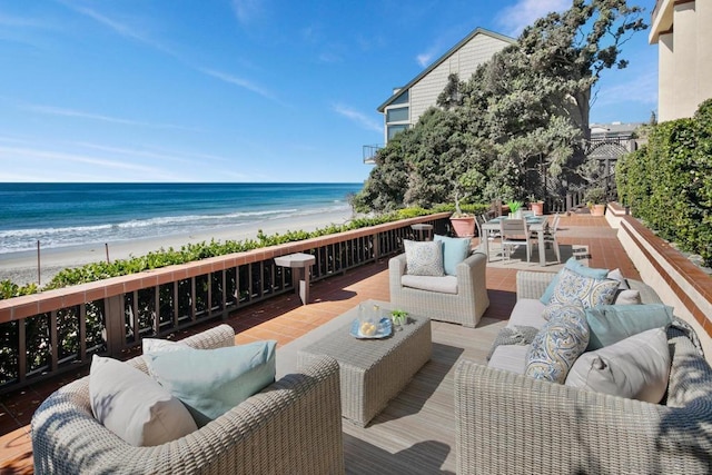 exterior space featuring a view of the beach, a water view, and an outdoor living space