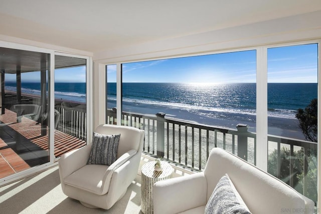 sunroom with a view of the beach and a water view