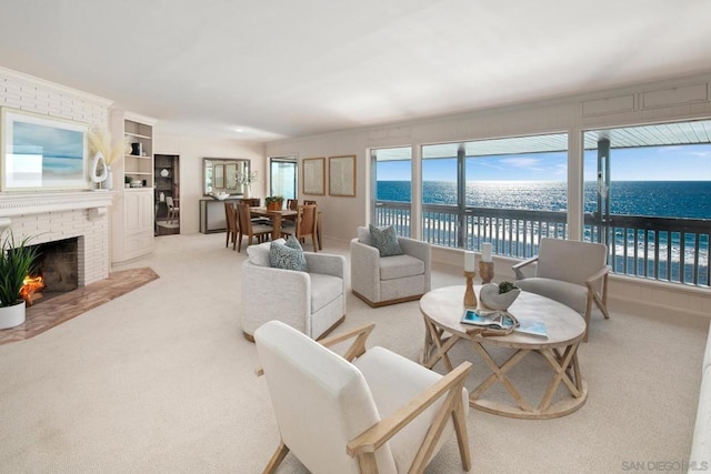 carpeted living room featuring a fireplace and a water view