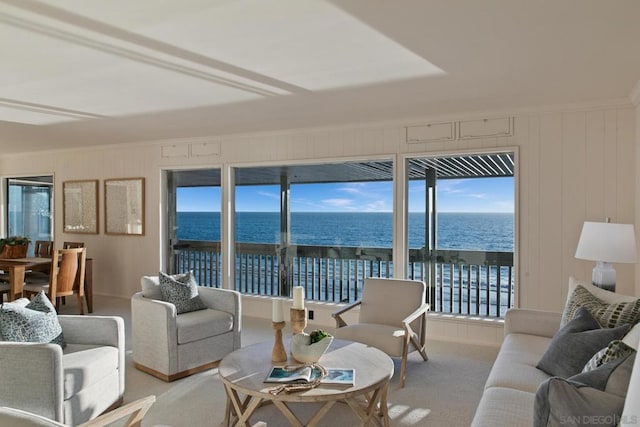 living room with light colored carpet, ornamental molding, and a water view