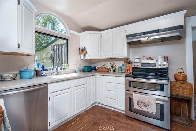 kitchen with appliances with stainless steel finishes, vaulted ceiling, white cabinetry, and dark wood-type flooring