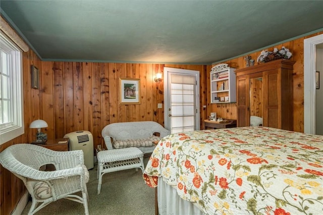 bedroom with carpet flooring, wooden walls, and ornamental molding