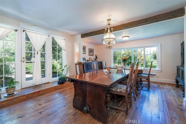 dining area with a chandelier, beamed ceiling, dark hardwood / wood-style flooring, and a healthy amount of sunlight