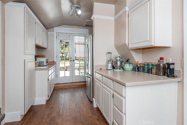 kitchen featuring french doors, dark hardwood / wood-style flooring, stainless steel fridge, lofted ceiling, and white cabinets