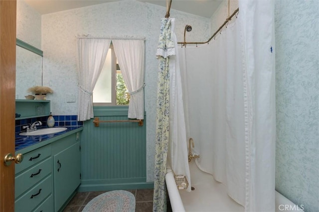 bathroom featuring tile patterned floors, shower / bath combo with shower curtain, and vanity