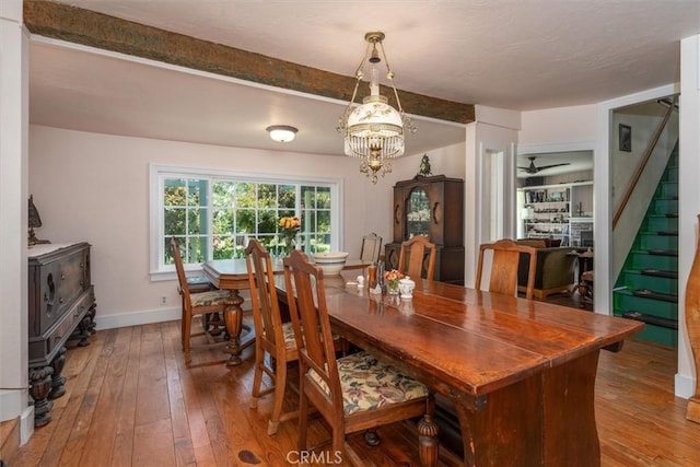 dining room featuring ceiling fan with notable chandelier and hardwood / wood-style flooring