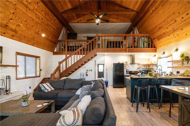 living room featuring light wood-type flooring, wood ceiling, ceiling fan, beam ceiling, and high vaulted ceiling