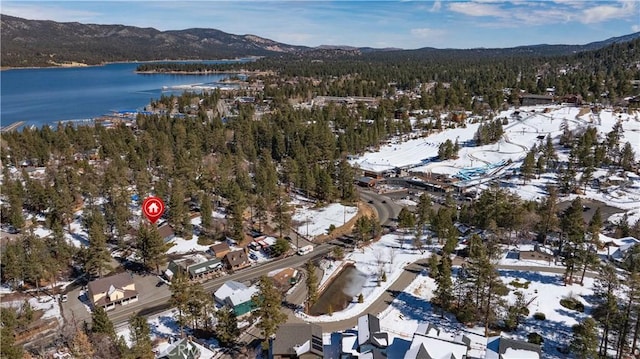 snowy aerial view featuring a water and mountain view