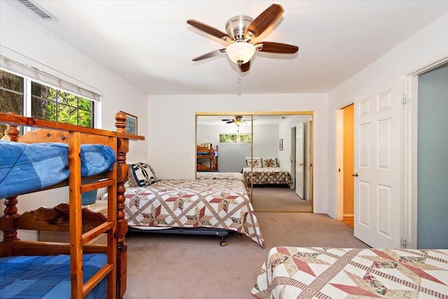 bedroom with ceiling fan, a closet, and light colored carpet