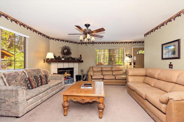 carpeted living room featuring a fireplace and ceiling fan