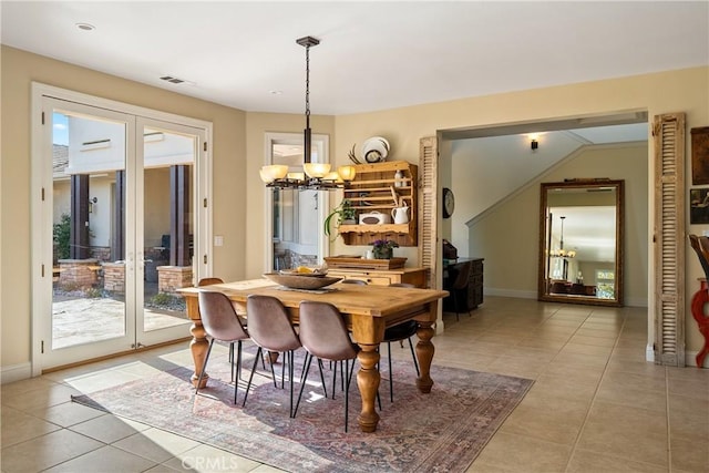 tiled dining space featuring a chandelier