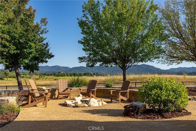 exterior space with a mountain view, a rural view, and an outdoor fire pit