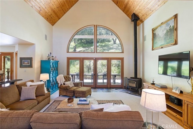 living room featuring wooden ceiling, a wood stove, and high vaulted ceiling