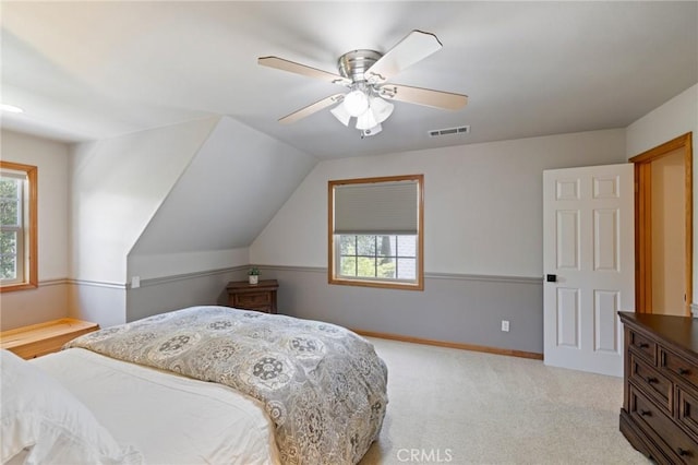 bedroom with ceiling fan, multiple windows, light carpet, and vaulted ceiling